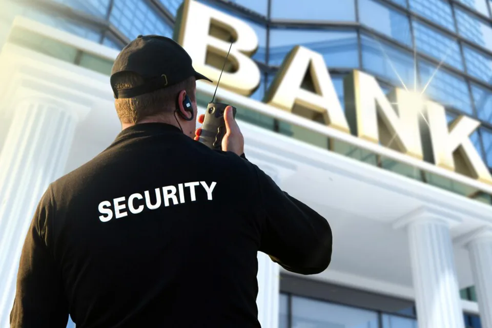 Security guard communicating by radio outside a bank building in Chicago