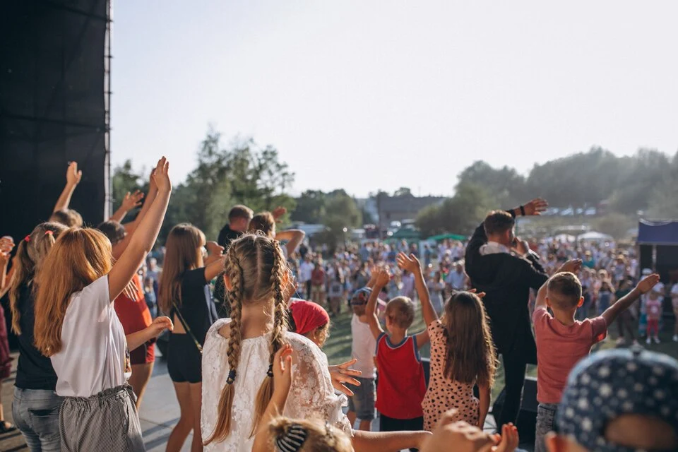 Crowd at a public event with staff on stage, supported by professional security presence