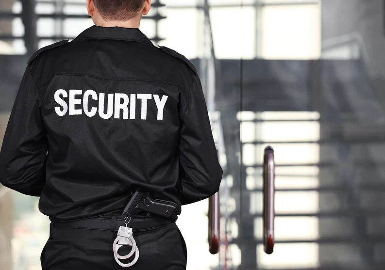Security officer in jacket at a building entrance as part of an executive protection detail - 60656