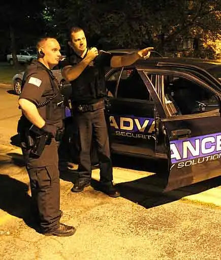 residential-security-services-chicago-illinois-60656 Residential security patrol officers beside a marked vehicle at night, responding to a call in Chicago, IL-60656