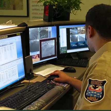 residential-security-services-chicago-illinois-60656 Residential security monitoring operator watching CCTV screens at a control desk in Chicago, IL 60656-60656