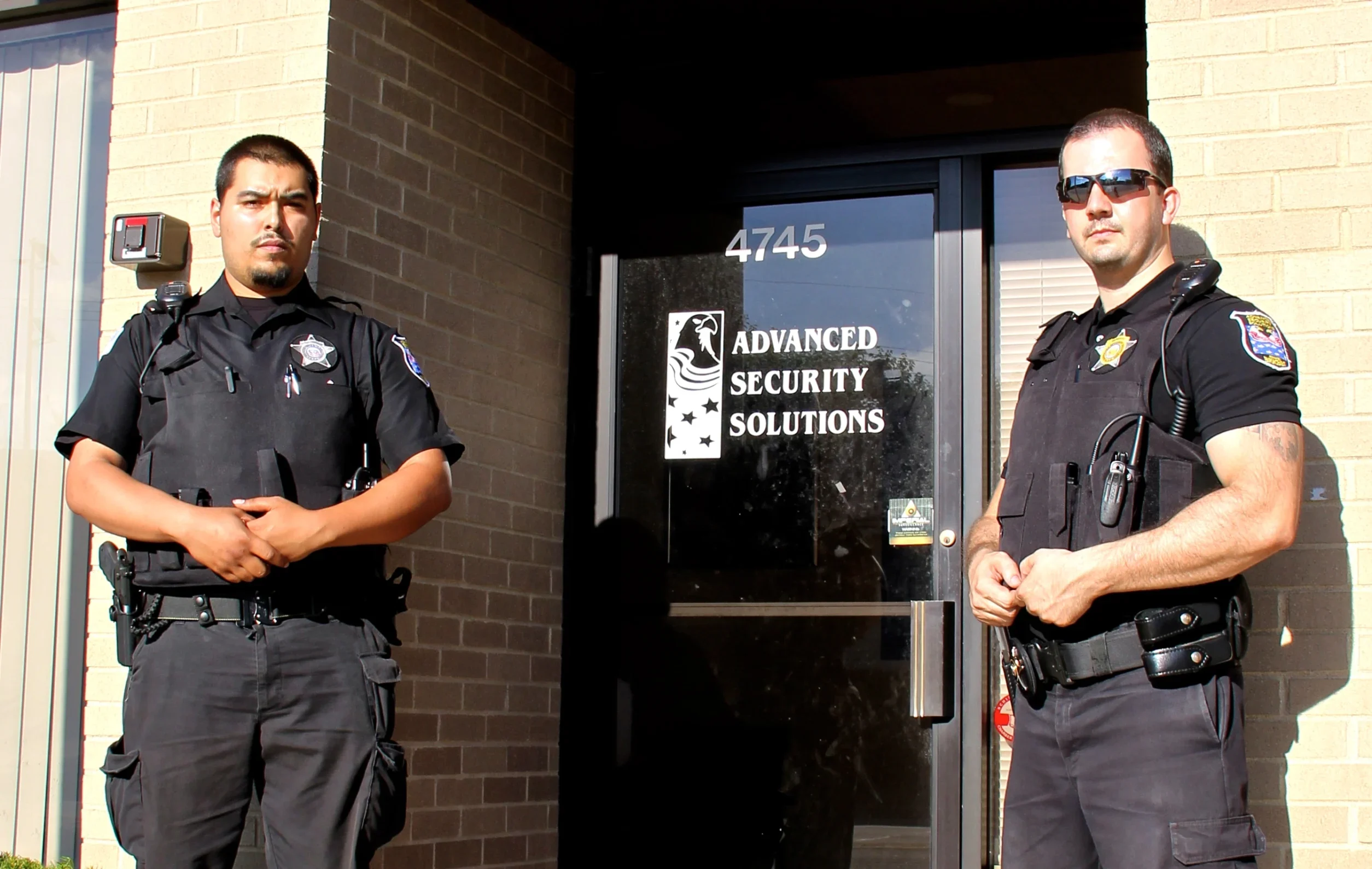 Two uniformed security guards standing at the entrance of Advanced Security Solutions for response & lockup services in Chicago, Illinois.