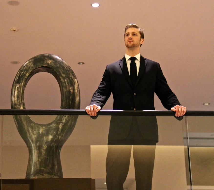 school-security-services-chicago-illinois-60656 Security consultant in a suit assessing a facility from an upper-level balcony