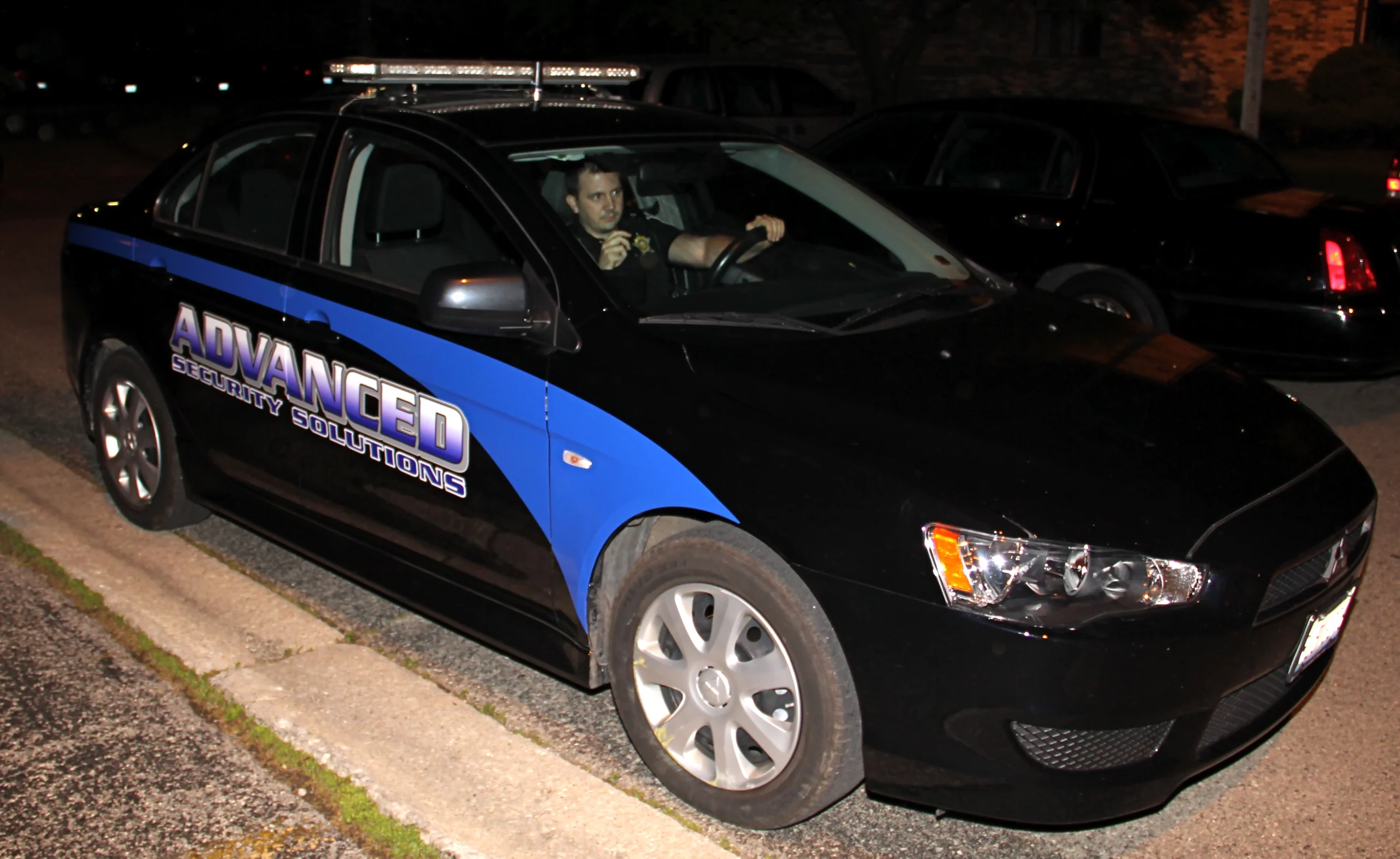 school-security-services-chicago-illinois-60656 Security patrol vehicle at night with an officer on the radio, ready to respond