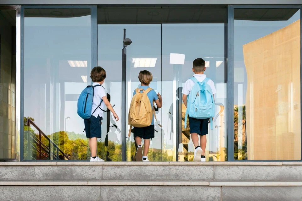 Students entering a school building, representing school security services in Chicago